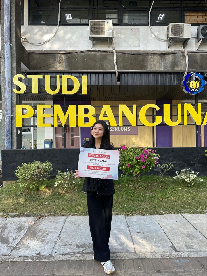 Aleyda holding the Setara Emas award certificate outside the Development Studies building